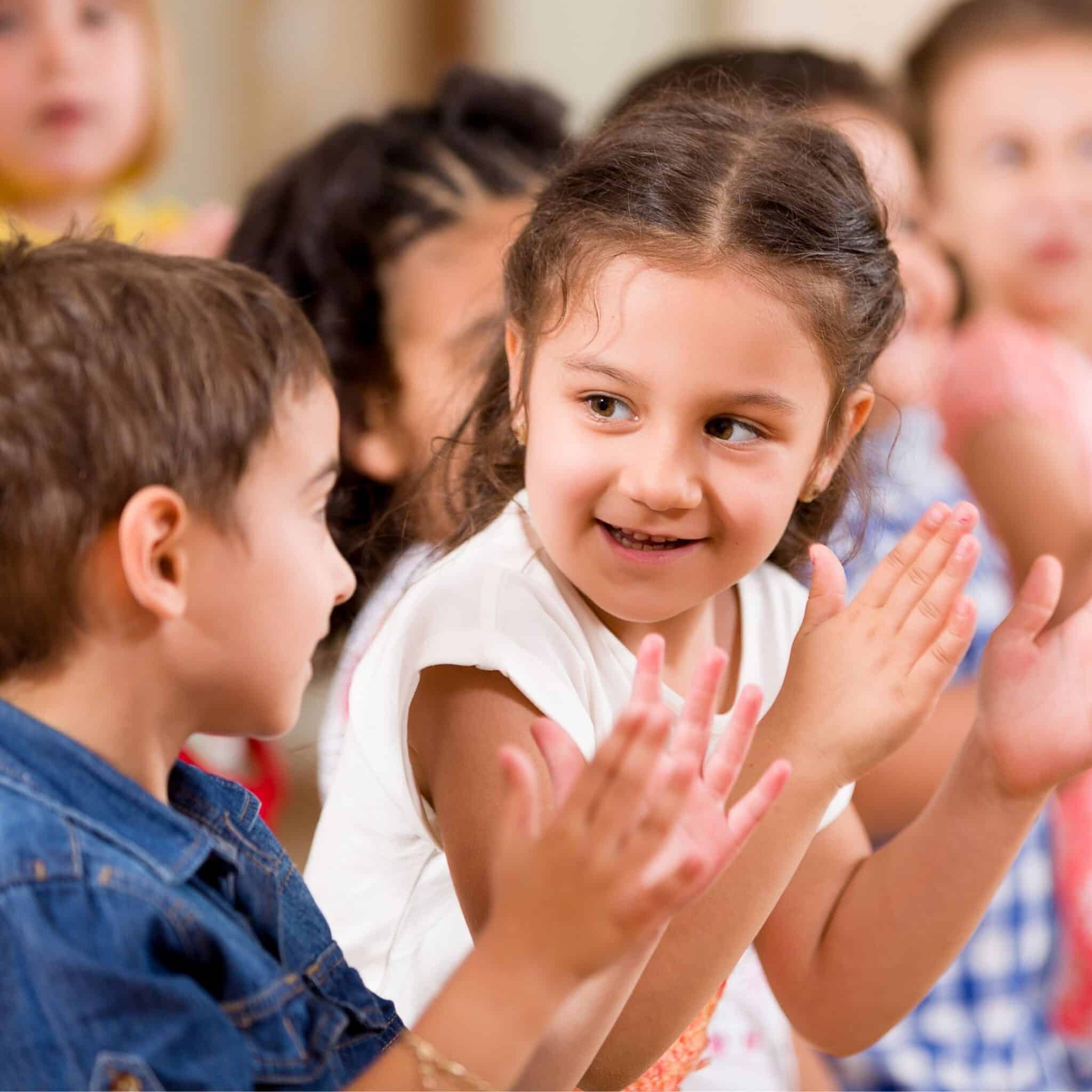 2 elementary music students smiling and clapping their hands